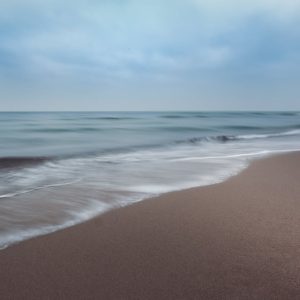 Beach Scenery - Tranquil ocean waves softly crashing on a sandy  #12399620