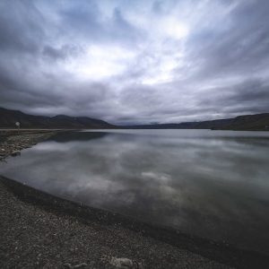 Lake Reflections - Serene mountain lake reflecting a dramatic cloud #18712421