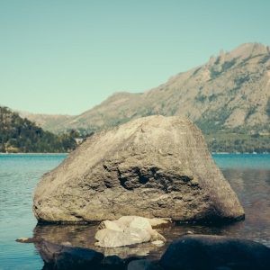 Lake Reflections - Rock in serene lake set against a majestic mount #31717345