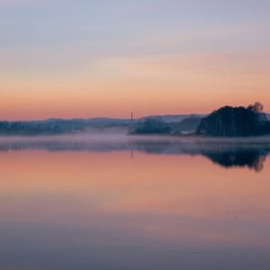 Lake Reflections - Peaceful scene of a misty lake reflecting the su #34670467